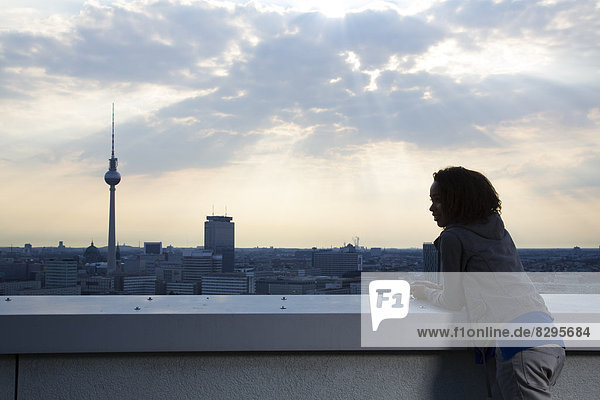 Young woman on rooftop terrace  looking at view
