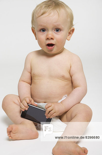 Baby Junge mit Smartphone  Studioaufnahme