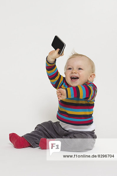 Baby boy playing with smart phone  studio shot