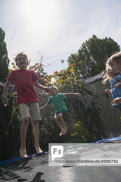 Children bouncing on trampoline