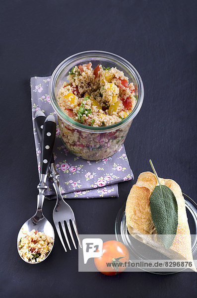 Couscous-Salat im Glas mit Baguette-Brot und Tomaten,  Nahaufnahme