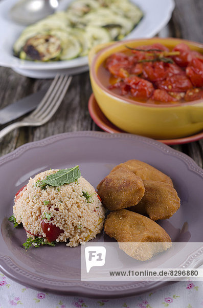 Vegetarian nuggets with couscous salad  zucchini and pickled tomatoes