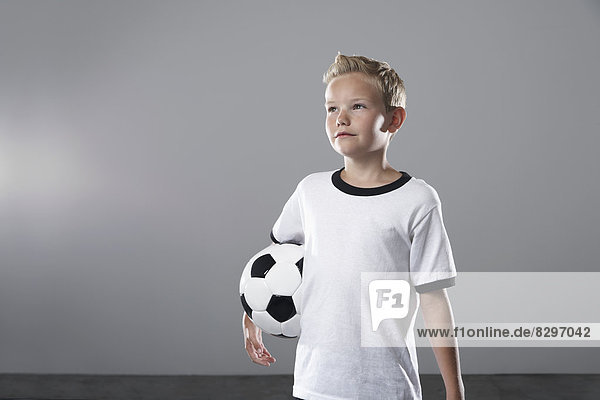 Boy in soccer jersey holding ball