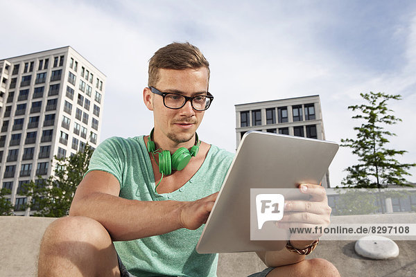 Young man with tablet computer outdoors