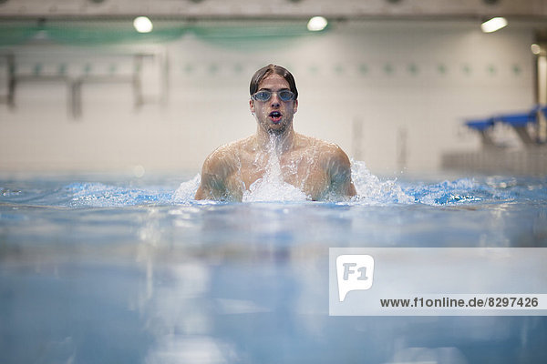 Breaststroke swimmer in indoor swimming pool