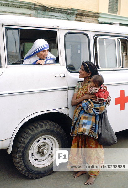 Mother Teresa talking with a poor woman and her child from a Red Cross minibus in Calcutta  India