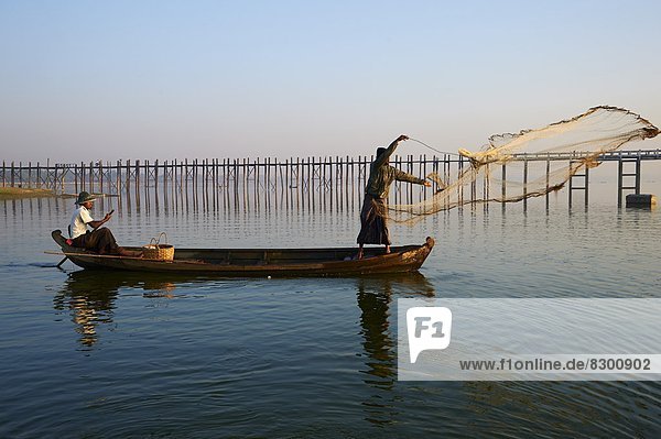 Fisherman on Taung Thama Lake and U Bein bridge at Amarapura  Mandalay Province  Myanmar (Burma)  Asia