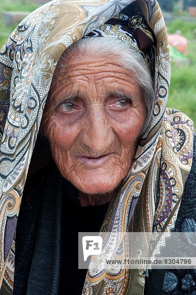 Elderly Armenian woman who sells woven and knitted souvenirs to tourists visiting the ancient gravestones at Noratus.