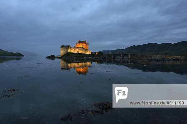 Eilean Donan Castle  ancestral seat of the Scottish clan of Macrae  reflected in Loch Duich in the evening