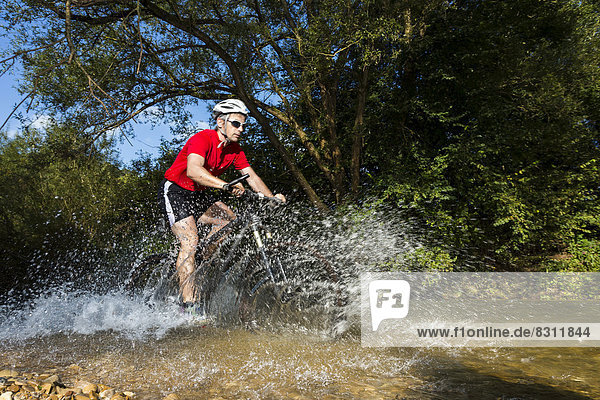 Mountain biker crossing a stream