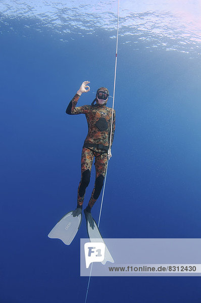 'Freediver wearing swimfins  making the gesture ''OK'''