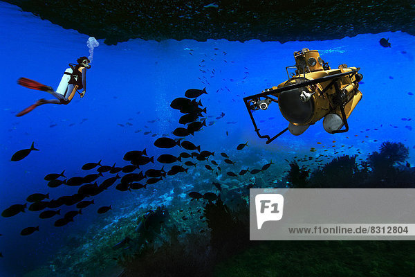 Scuba diver and a submarine in an underwater cave  composite image