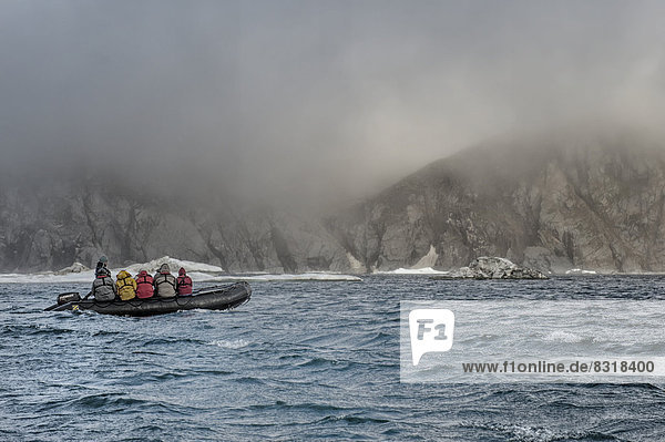 Touristen in einem Schlauchboot vor Herald Island  UNESCO-Weltkulturerbe
