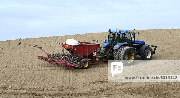 Tractor planting wheat seeds in autumn