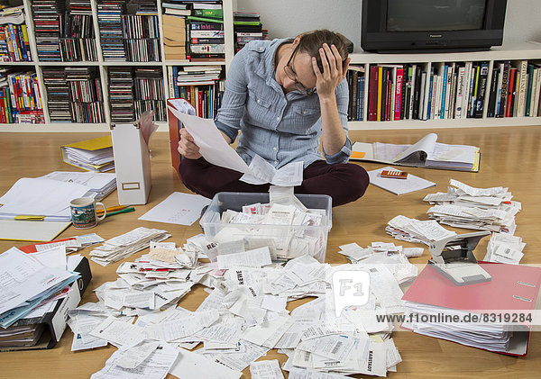 Woman sorting documents  records  invoices and receipts on the ground  for the tax return