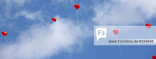 Red heart balloons in the sky
