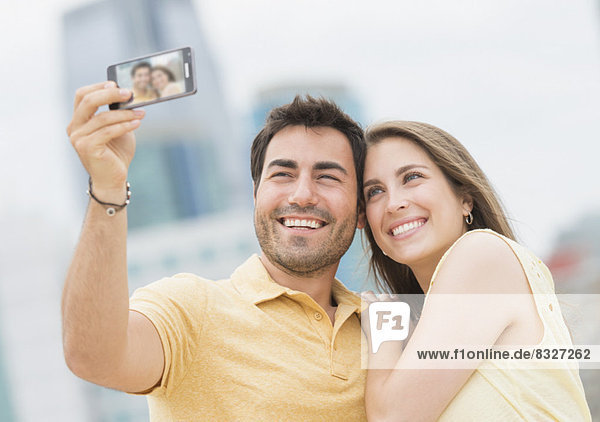 Couple taking self portrait photo with smartphone