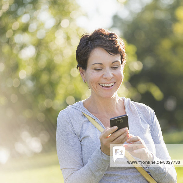 Mature woman text messaging outdoors