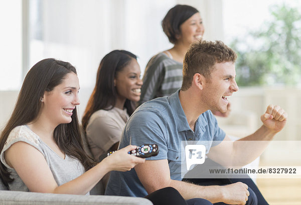 Friends watching tv on sofa