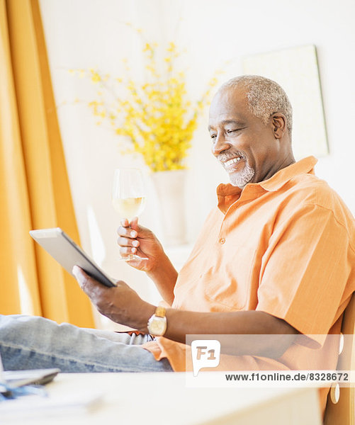 Portrait of men using digital tablet and holding wine glass