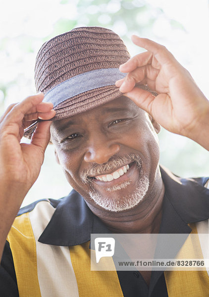 Portrait of happy senior man wearing straw hat