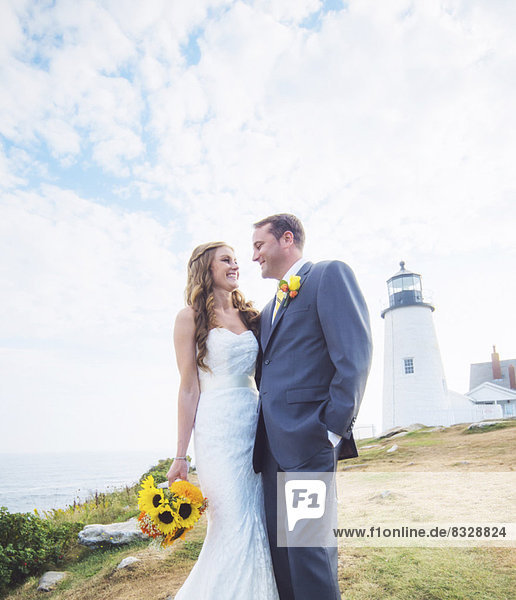 Portrait of married couple  lighthouse in background