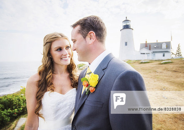 Portrait of married couple  lighthouse in background