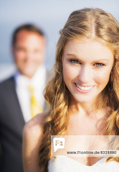 Portrait of smiling bride  groom in background