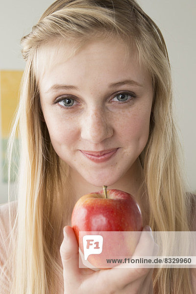 Girl (14-15) holding apple