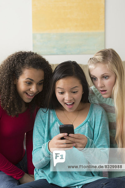 Girls (12-13 14-15 16-17) playing with smartphone