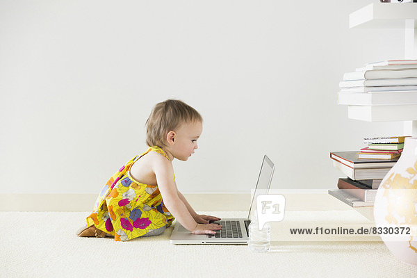 Girl (12-17 months) using laptop