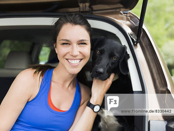 Woman sitting in car with dog