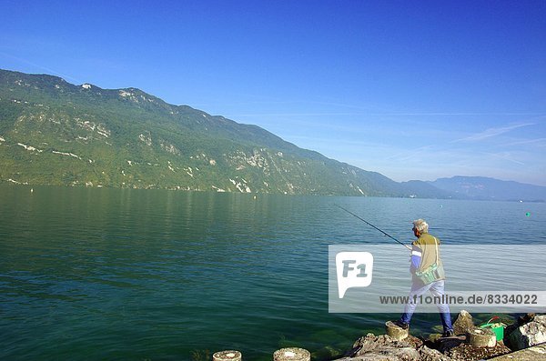 'Angler on the rocks by the ''Lac du Bourget'' (''Lake of Bourget'') (73)  mountains far off'