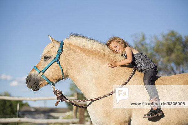 A young girl sitting on a horse.
