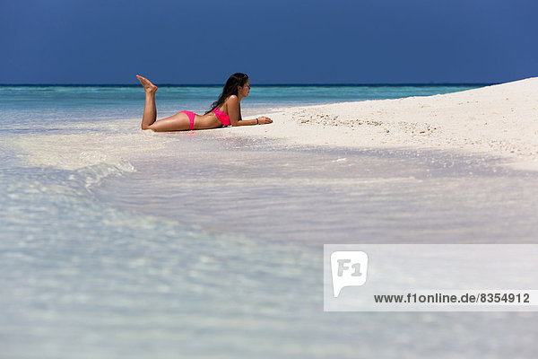 Woman in a pink bikini lying on the beach  Male  North Male Atoll  Maldives