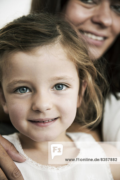 Porträt des kleinen Mädchens mit ihrer Mutter im Hintergrund