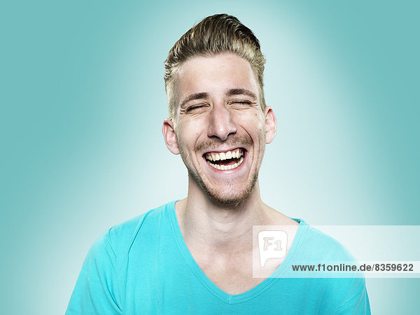 Portrait of laughing young man  studio shot