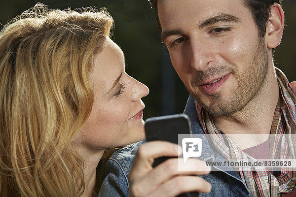 Germany  Dusseldorf  Young couple with mobile phone