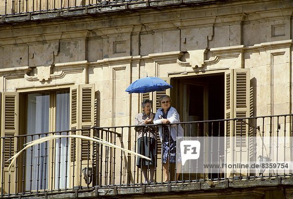 Frau sehen Schutz Regenschirm Schirm Senior Senioren Balkon Portugal Sonne