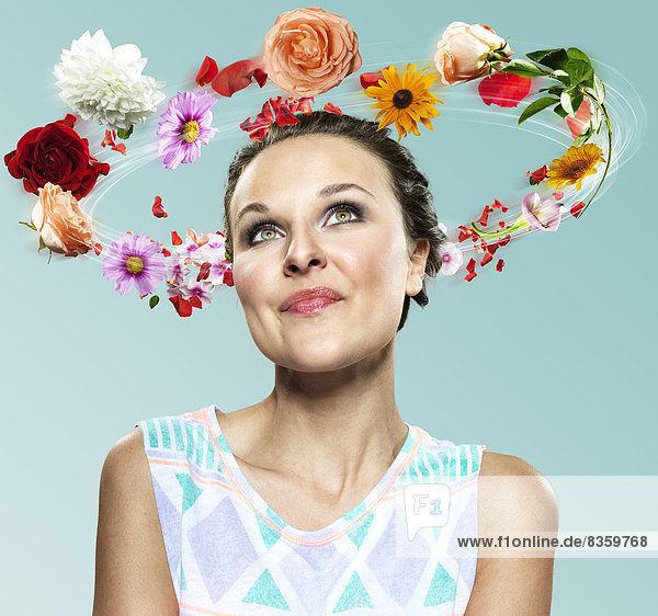 Young woman with flying flowers around her head,  Composite