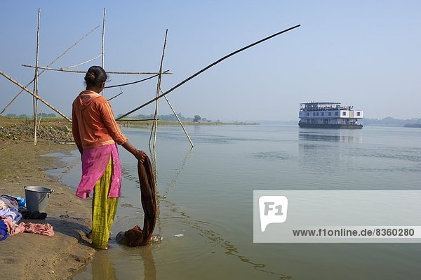 Woman with laundry and sukapha boat on the Hooghly River  part of Ganges River  West Bengal  India  Asia