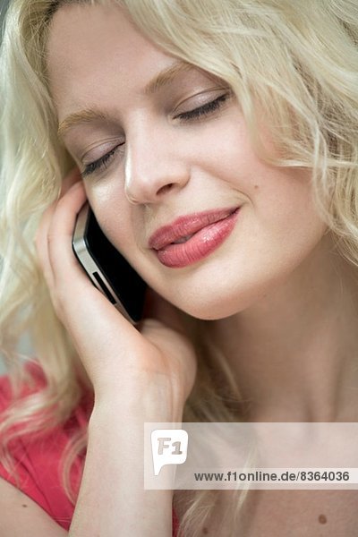 Young woman on cellphone with eyes closed