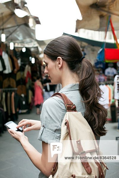Junge Frau SMS am Handy  San Lorenzo Markt  Florenz  Toskana  Italien