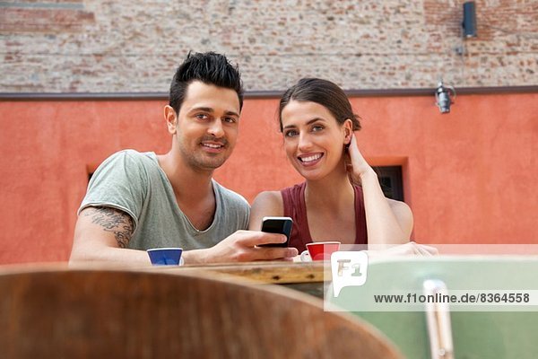 Paar mit Smartphone vor dem Café  Florenz  Toskana  Italien