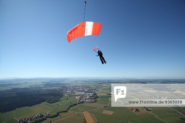 Fallschirmspringer mit Fallschirm über Leutkirch,  Bayern,  Deutschland