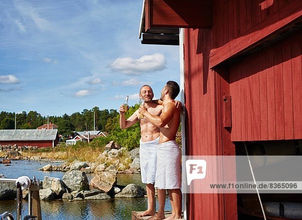 Zwei Männer mit Bier vor der Sauna