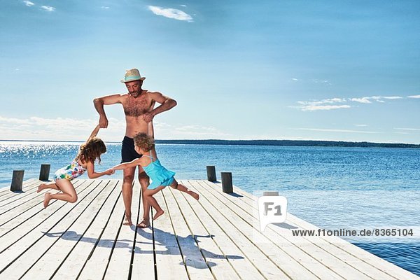 Vater und Töchter spielen am Pier  Utvalnas  Gavle  Schweden