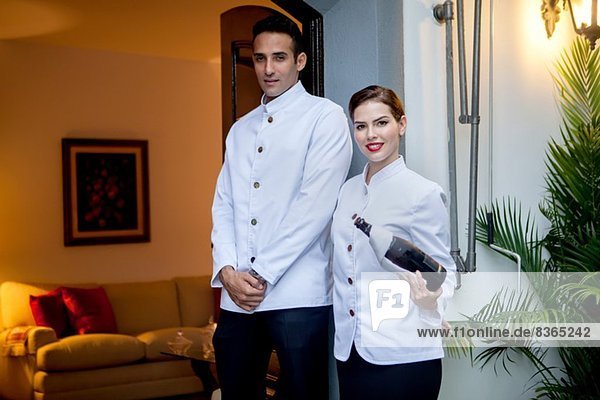Hotel staff at entrance with bottle of champagne