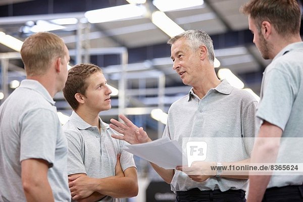 Manager and workers meeting in engineering factory