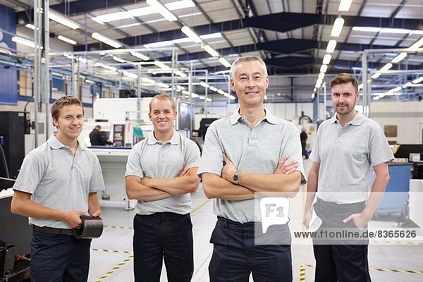 Portrait of manager and workers in engineering factory